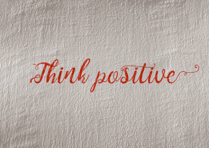 'think positive' morning affirmation in cursive on wall