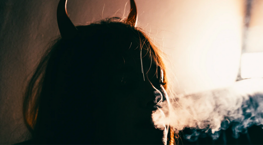 Woman in devil horns smoking - how to become rich
